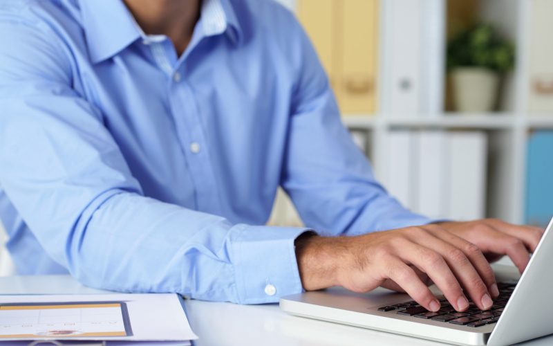 Working on computer Cropped image of businessman working on laptop