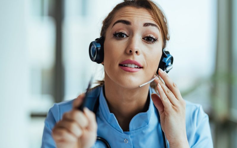It is very important that you listen to health experts in this s Young female doctor wearing headset and talking with patients while working at medical call center and looking at camera.