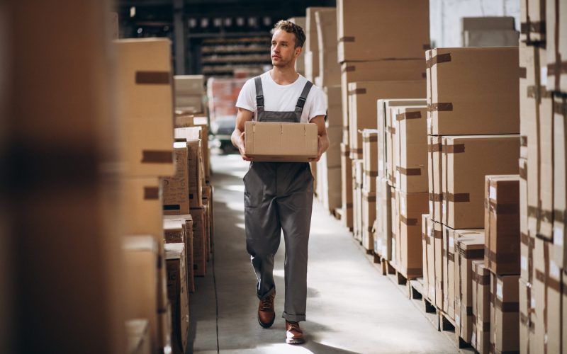 Young man working at a warehouse with boxes Young man working at a warehouse with boxes